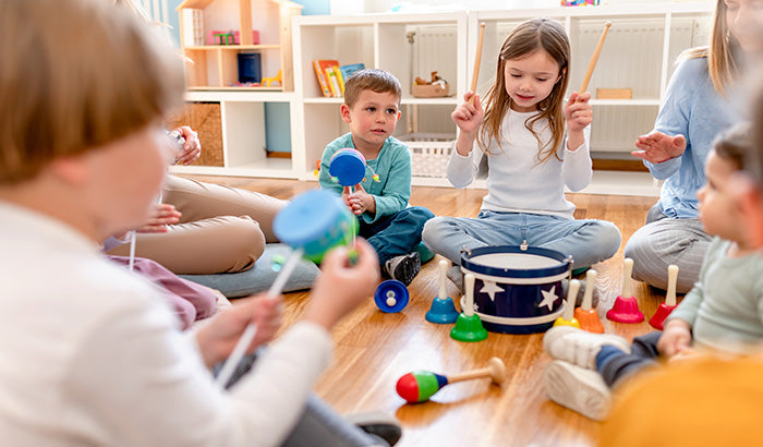 Children playing with musical instruments in a classroom. Music With Toys, Gifts, Baby’s First