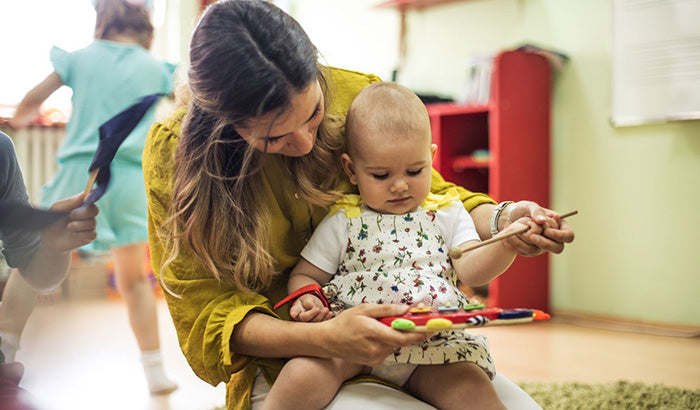 woman holding baby, playing with toy. mozart and music, chopin classical music, beethoven classics